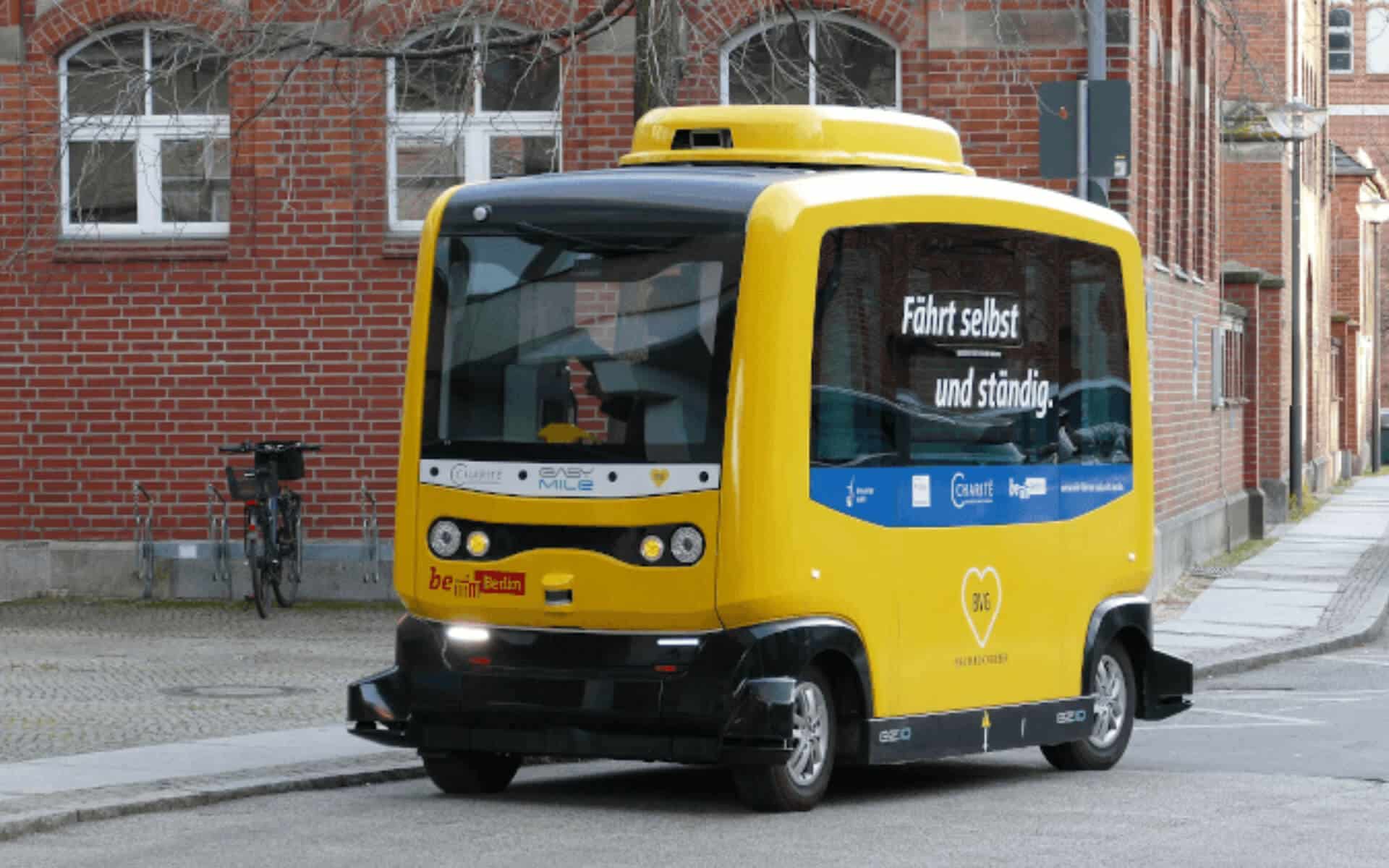 A driverless taxi takes on a passenger on a European street